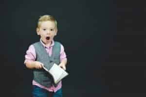 small boy with journal, suprised